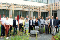 17 Männer und Frauen stehen in einem Innenhof der Hochschule Weihenstephan-Triesdorf. Vor einem Fachforum haben sie sich für ein gemeinsames Foto aufgestellt.